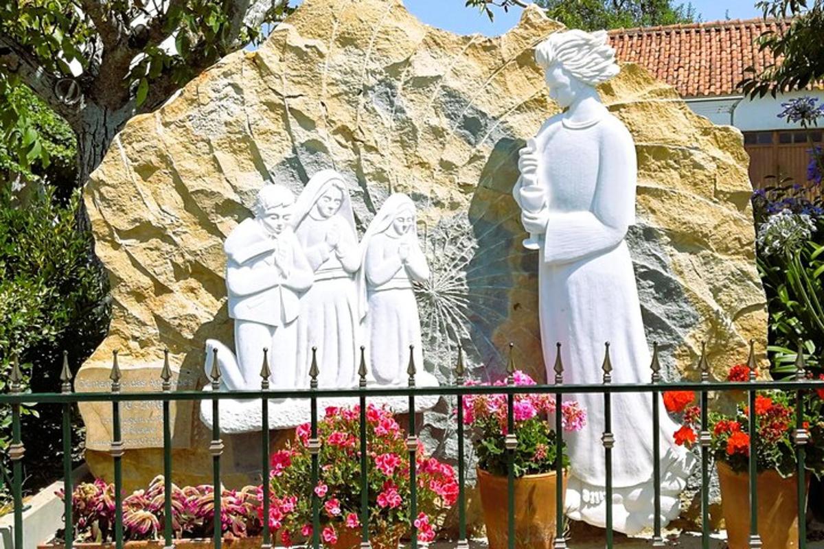 a statue of a group of women in front of a rock
