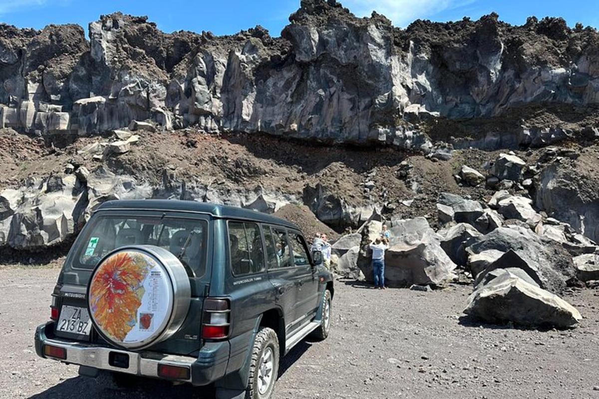 sebuah suv hijau diletakkan di atas gunung berbatu