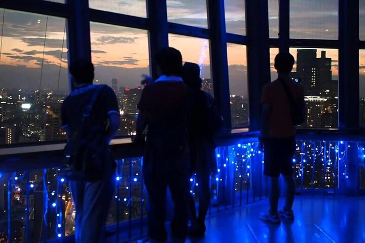 a group of people looking out of a window at a city skyline