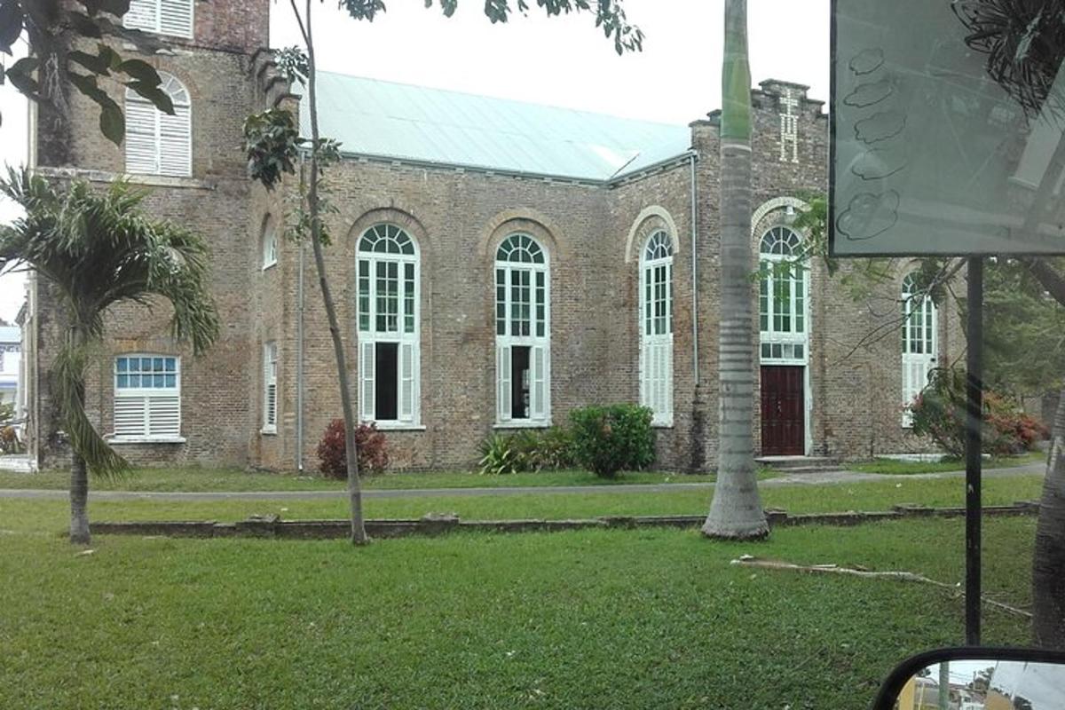 an old brick building with a palm tree in front of it