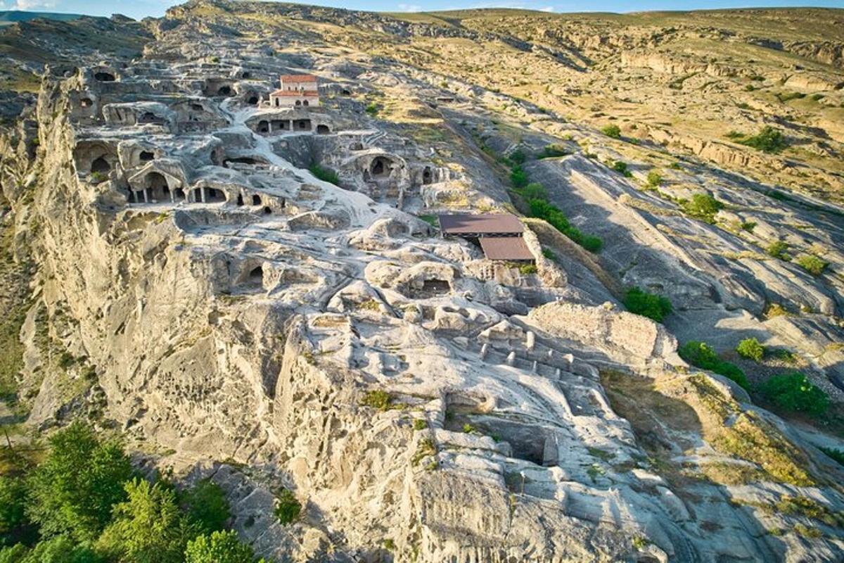 an aerial view of a rocky mountain with dwellings on it