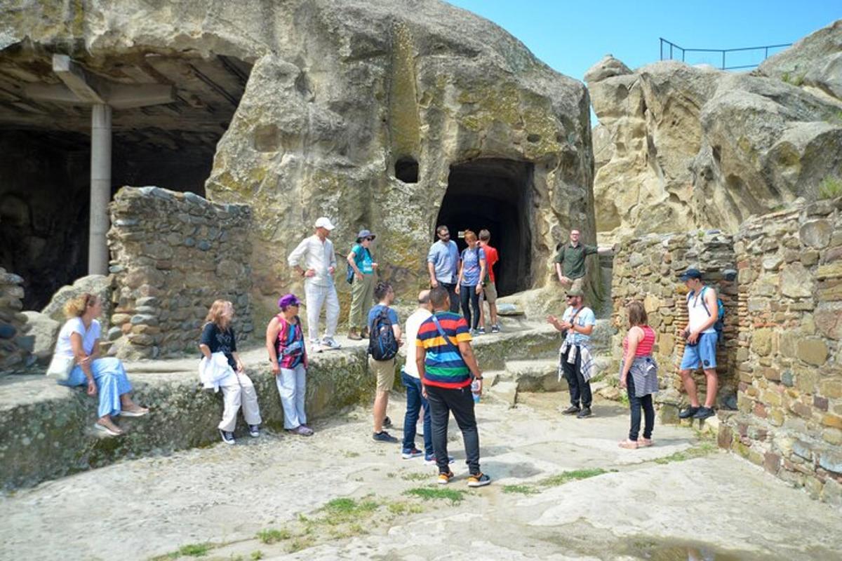 a group of people standing outside of a cave