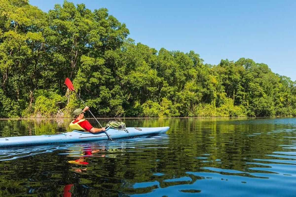 una donna sta pagaiando su un kayak su un lago