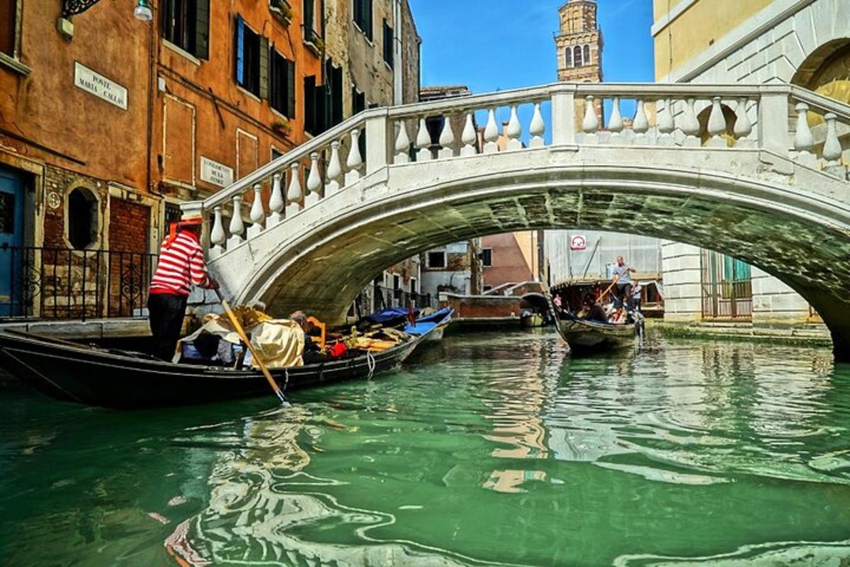 Un puente sobre un río con góndolas en el agua.