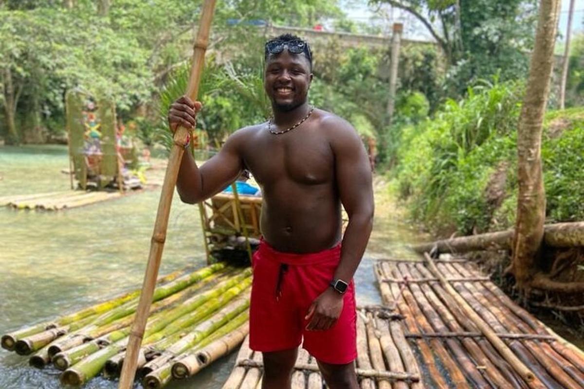a man in red shorts holding a wooden stick