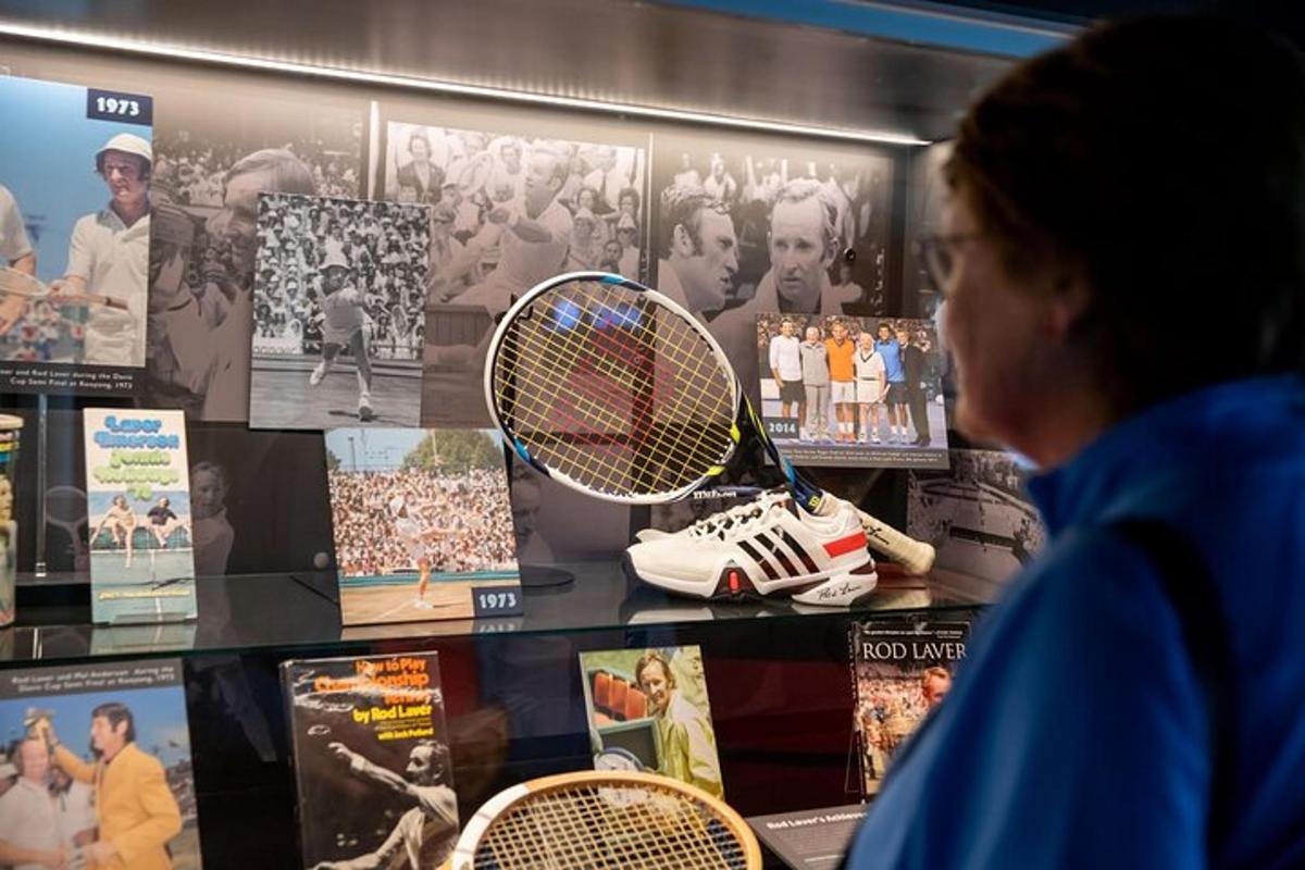 eine Frau, die sich eine Ausstellung mit Tennisschlägern ansieht
