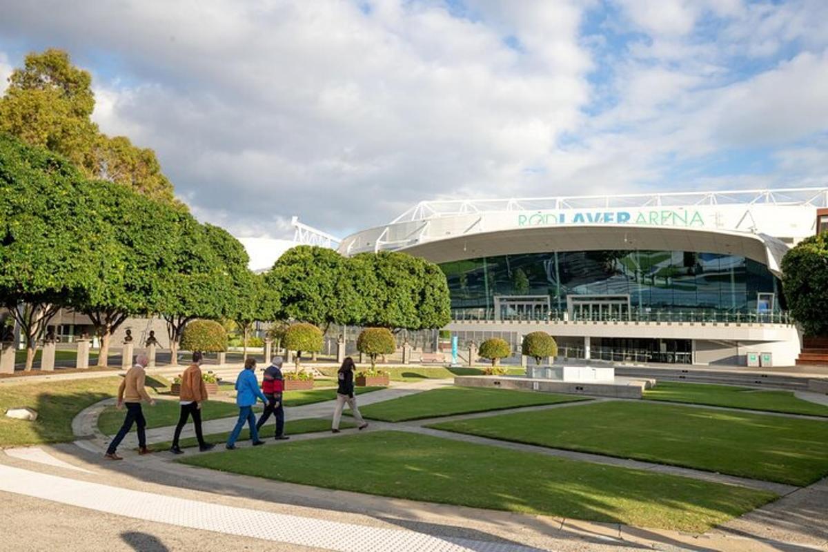 um grupo de pessoas caminhando em frente a um estádio
