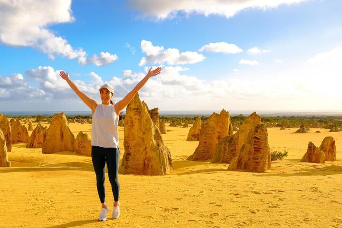 Una mujer parada en el desierto con los brazos en alto