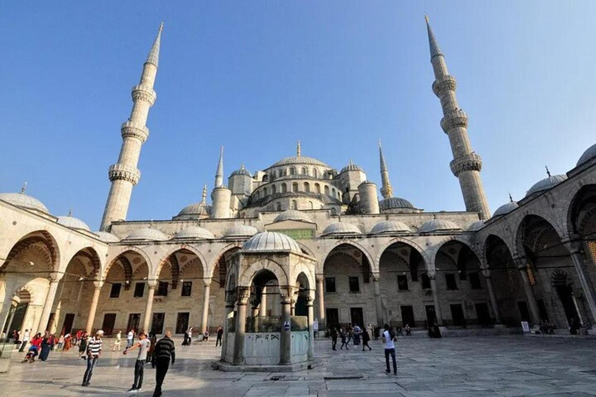 a large building with two mosques with people standing around it