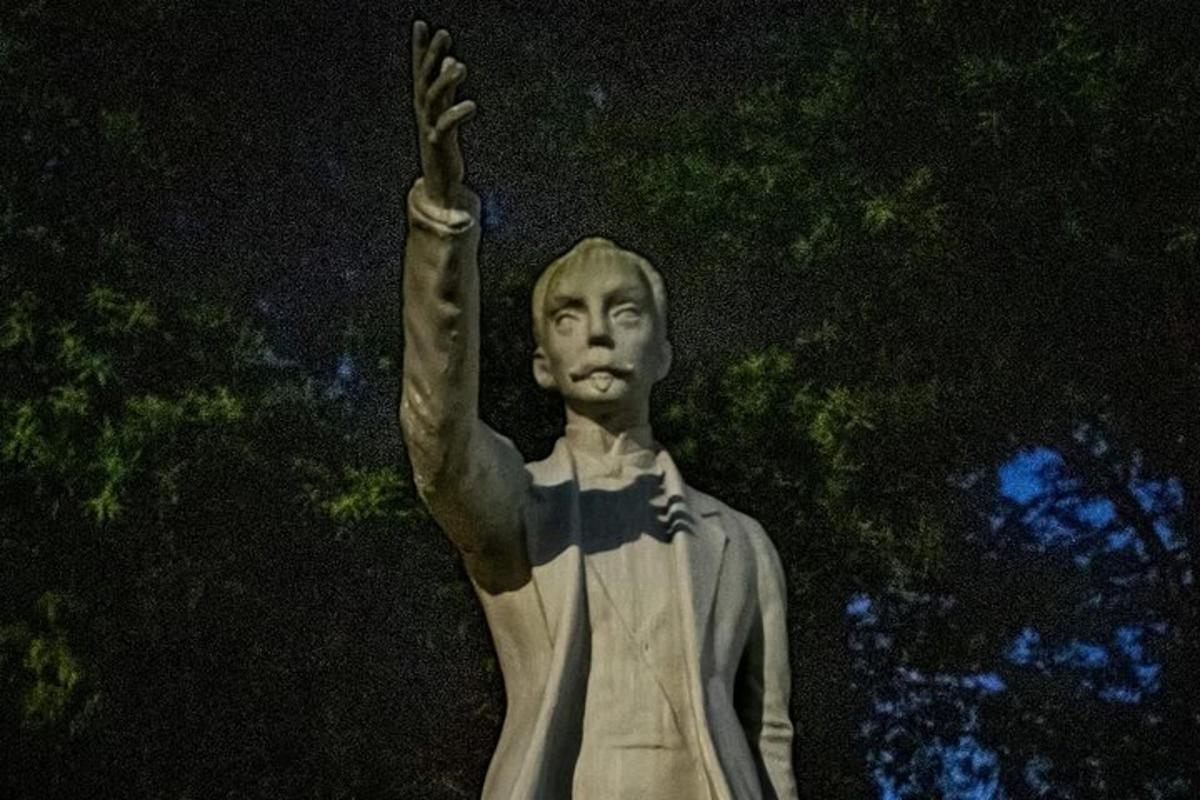 uma estátua de um homem com a mão no ar