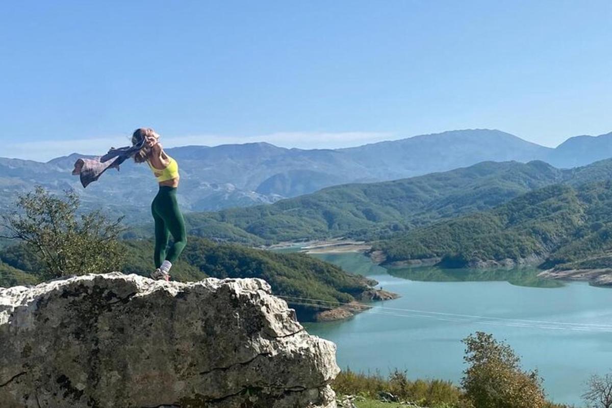 žena stojí na vrcholu skály