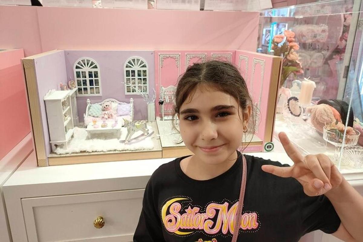 Una niña señala una casa de muñecas en una tienda.