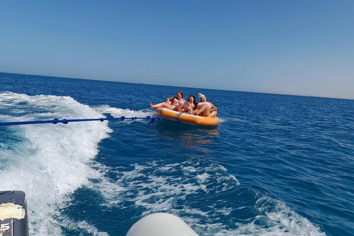 eine Gruppe von Menschen auf einem orangefarbenen Floß im Wasser