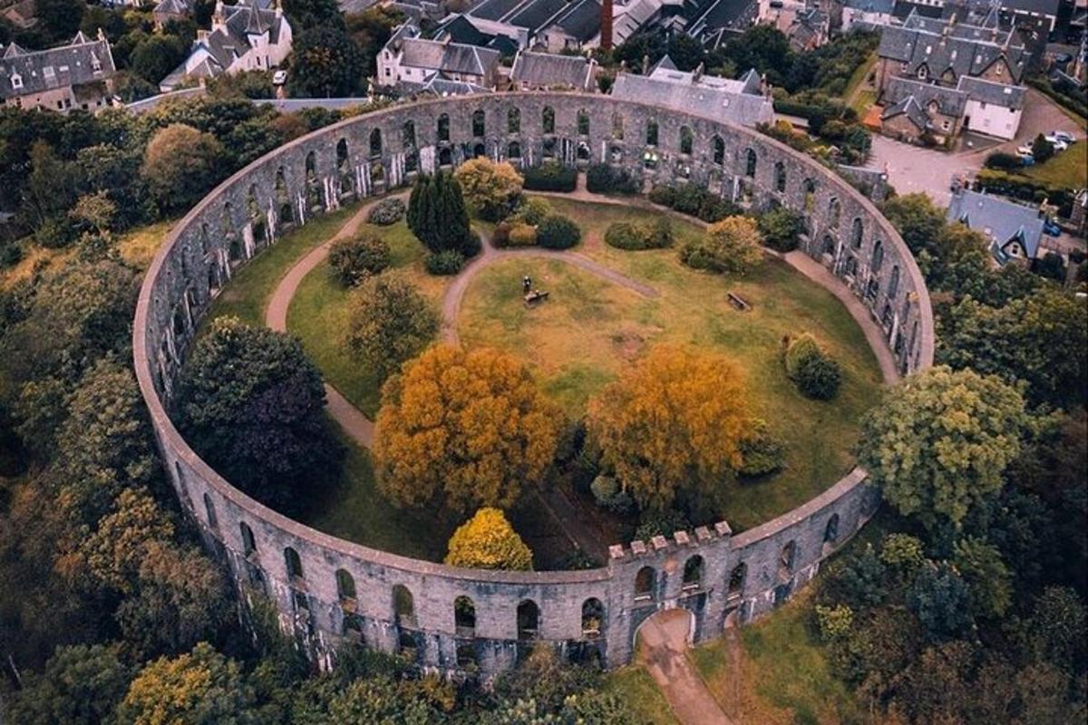 un edifici antic en un turó amb arbres i cases