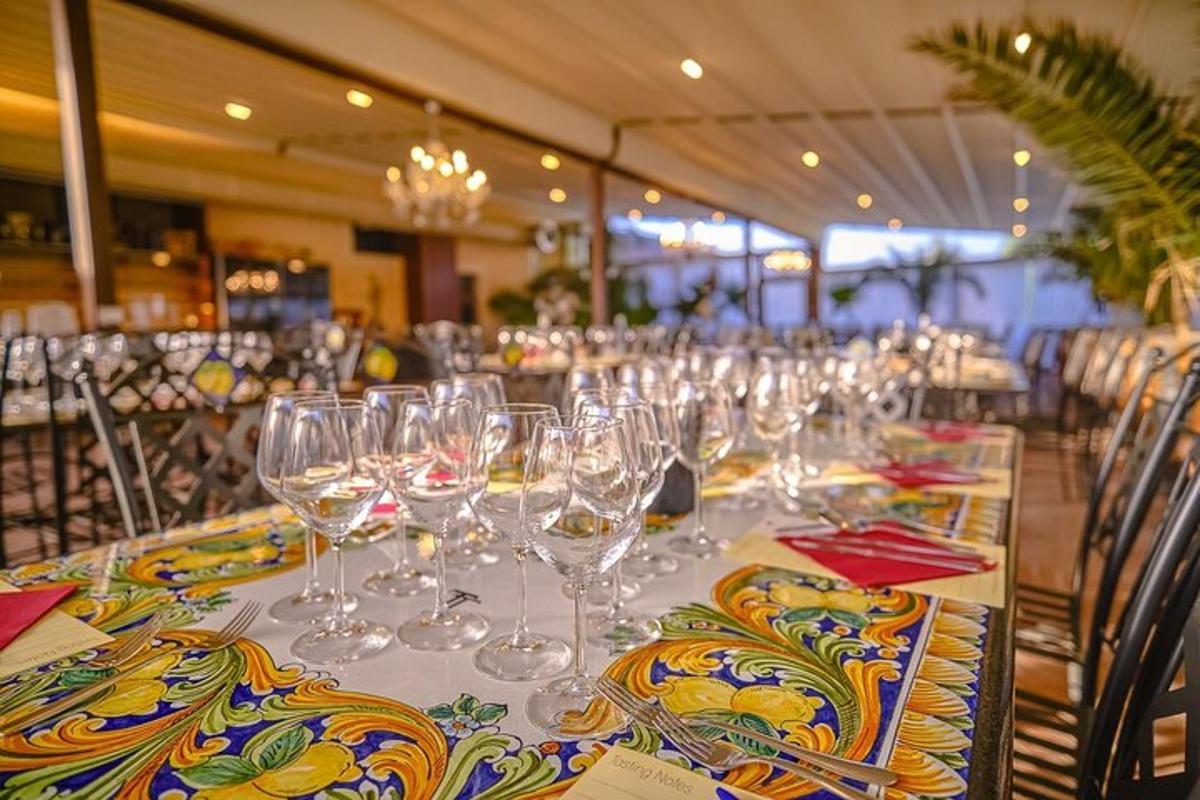 Una mesa larga con copas de vino encima.