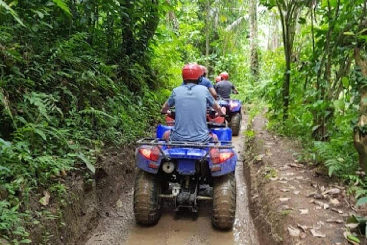 un grup de persones anant en una moto de cross a la selva