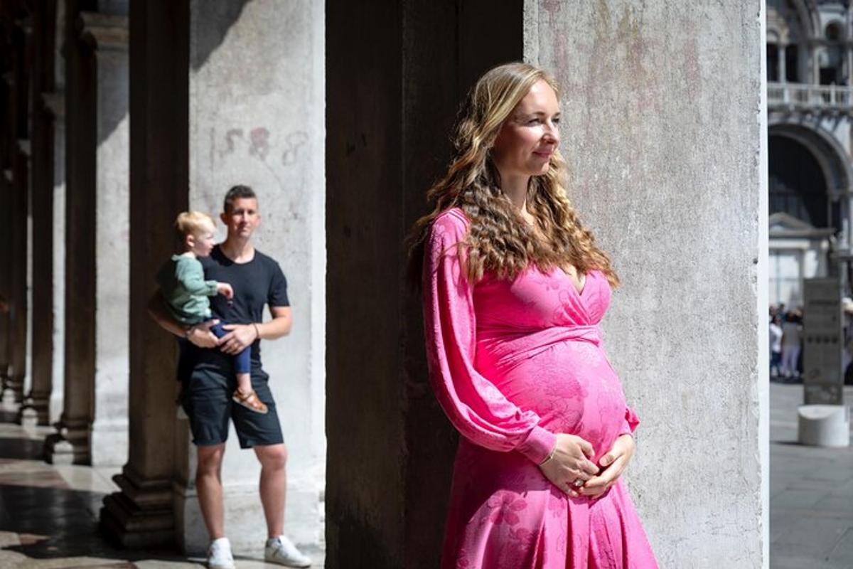 una donna incinta in piedi accanto a una colonna con un uomo e un bambino