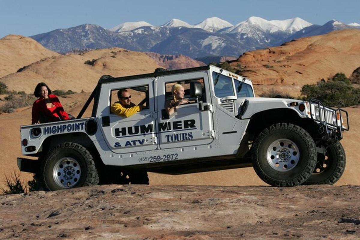 a white jeep driving in the desert