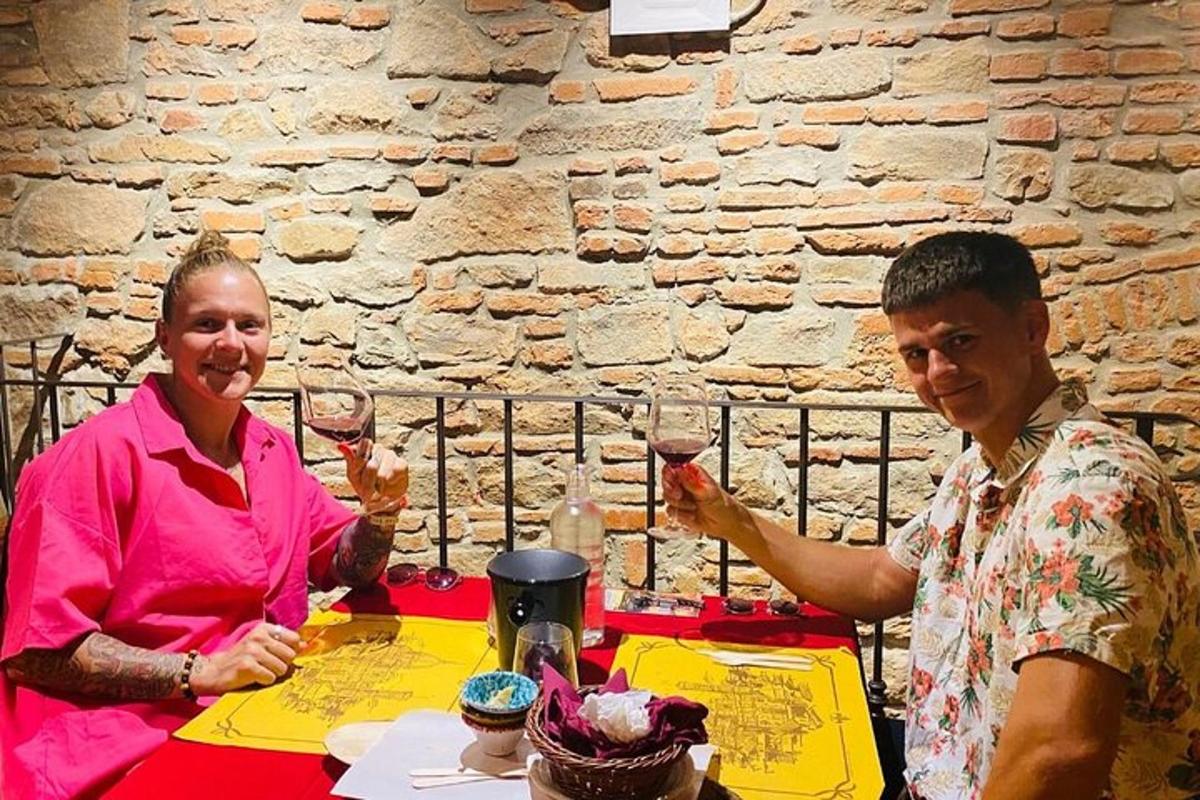 a man and woman sitting at a table with wine glasses