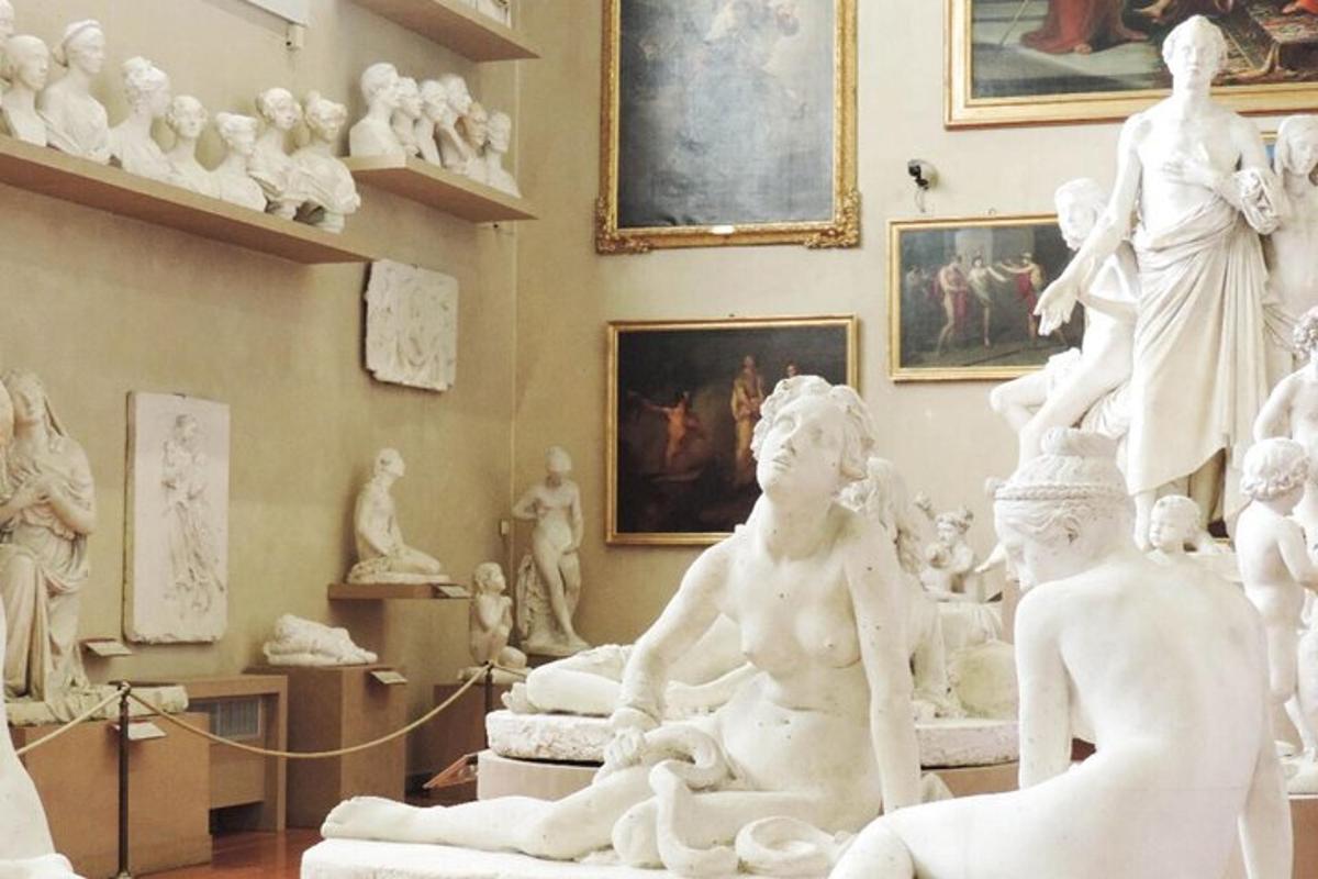 una stanza con statue bianche e dipinti sul muro