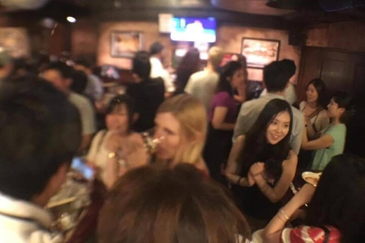 um grupo de pessoas em pé no meio da multidão em um bar