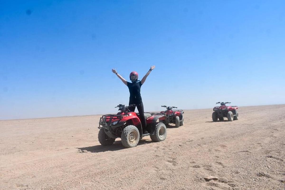eine Person, die auf einem Quad in der Wüste steht