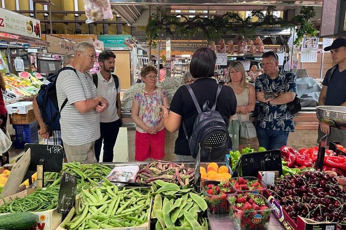 a group of people standing in a market with vegetables