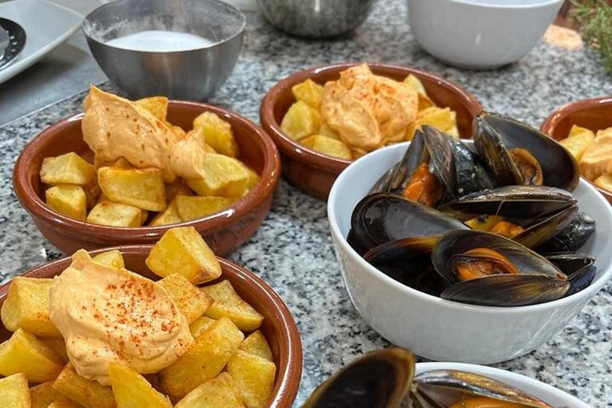 four bowls of food with mussels and chips on a table