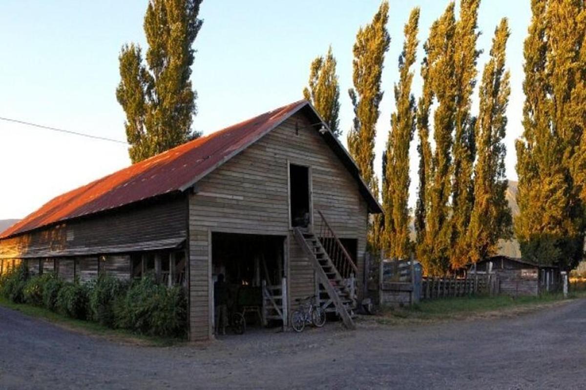an old barn with a red roof and a bicycle in front