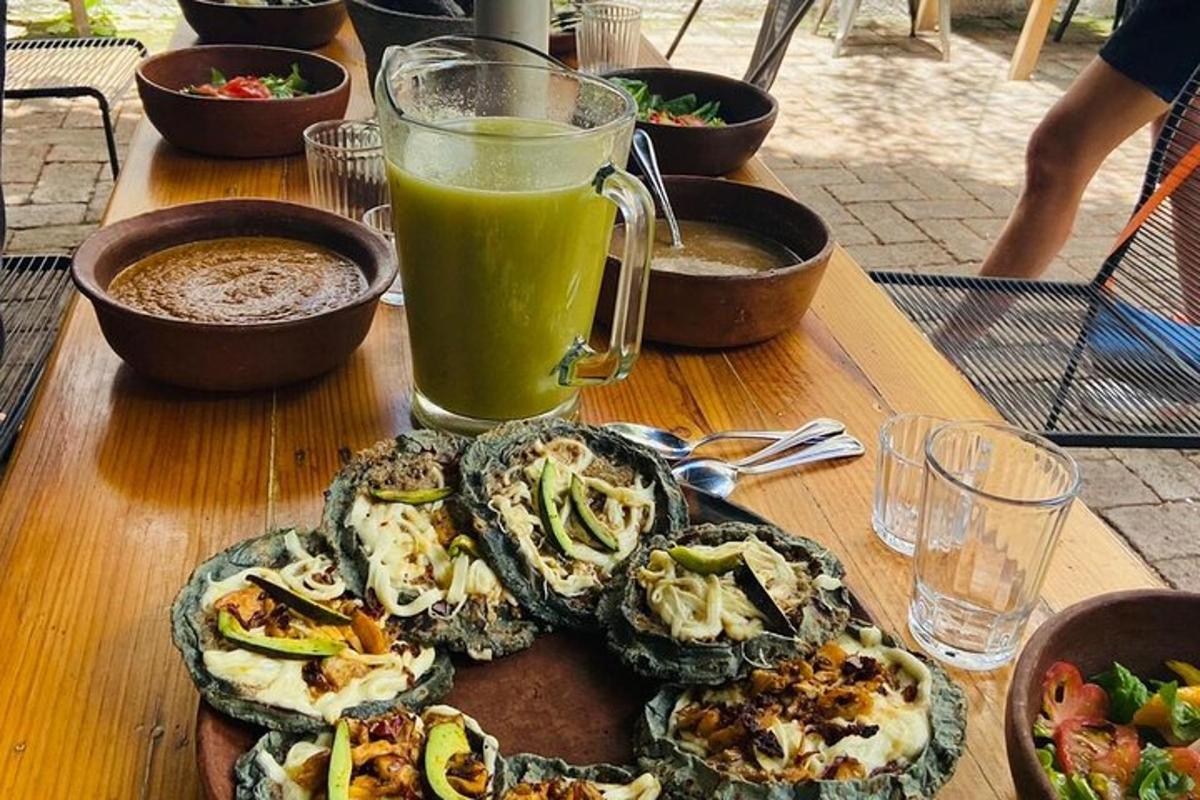 a wooden table with a plate of food and a glass of juice