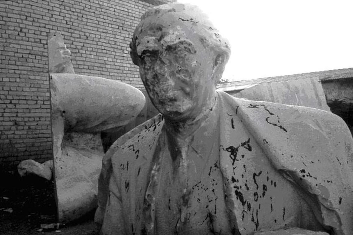 una statua di un uomo in piedi accanto a un edificio in mattoni