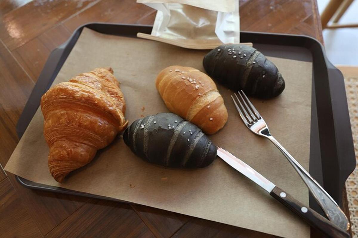 uma bandeja com pão e croissants e um garfo