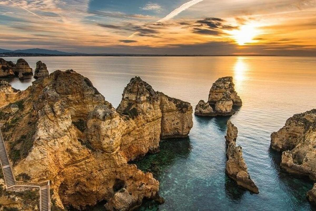 Západ slunce nad oceánem s kameny ve vodě