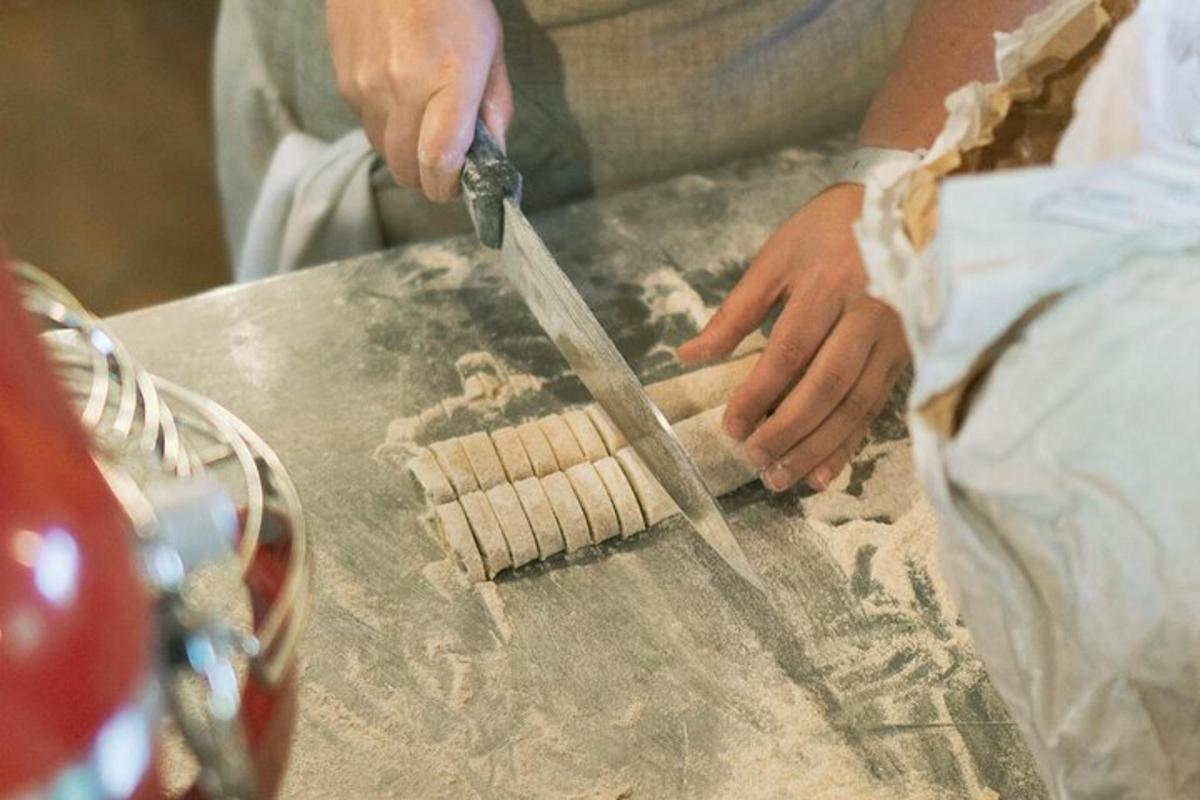 a person cutting a piece of dough with a knife