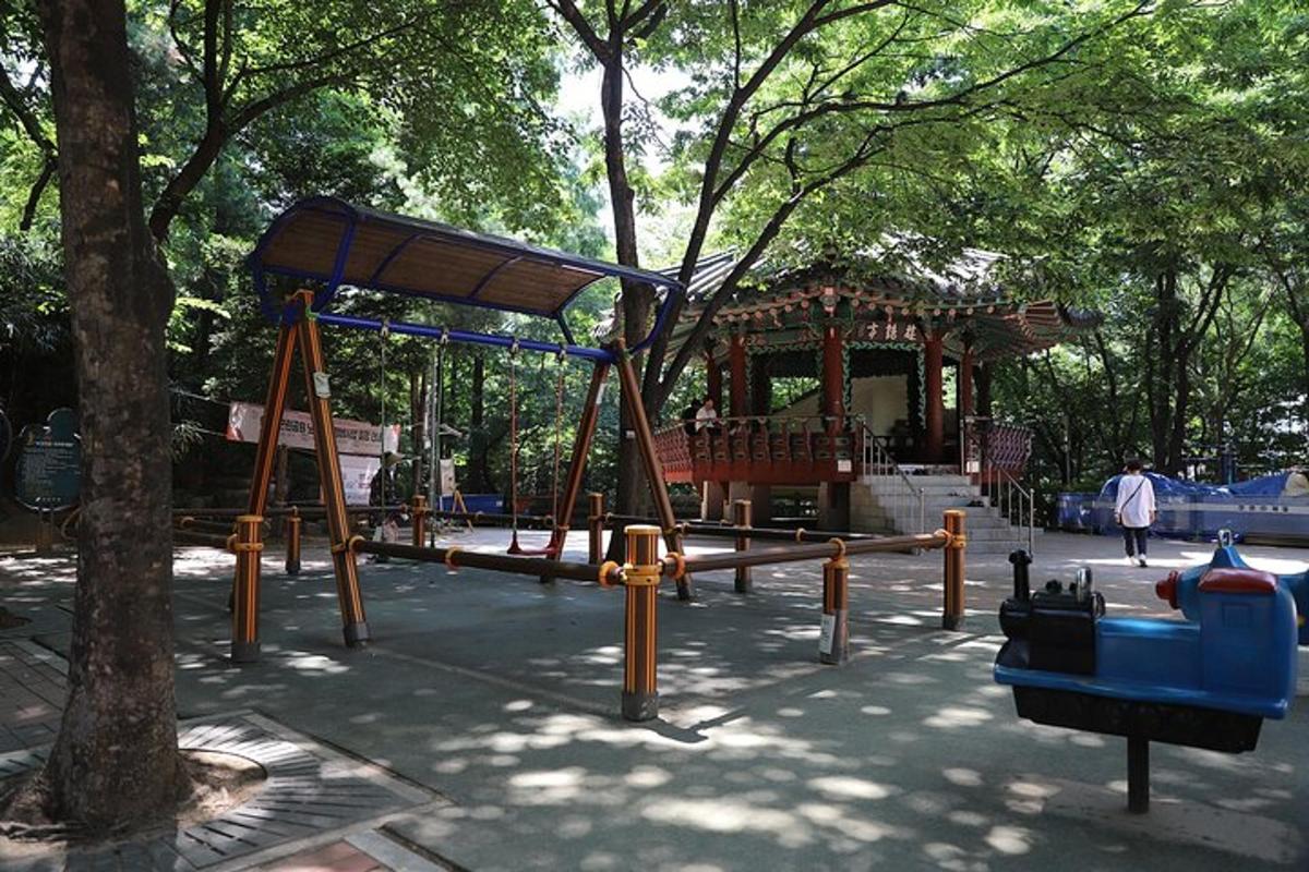 um playground em um parque com uma árvore
