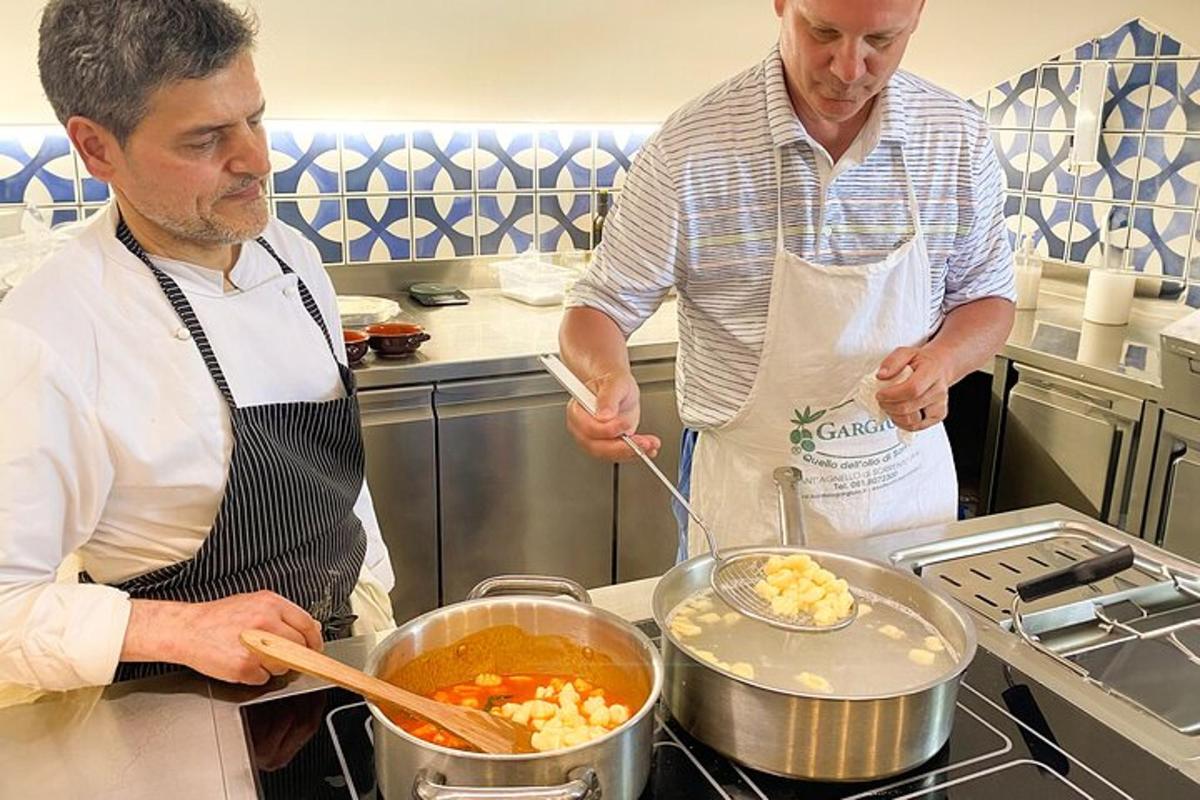 twee mannen in een keuken die eten bereiden in een pot