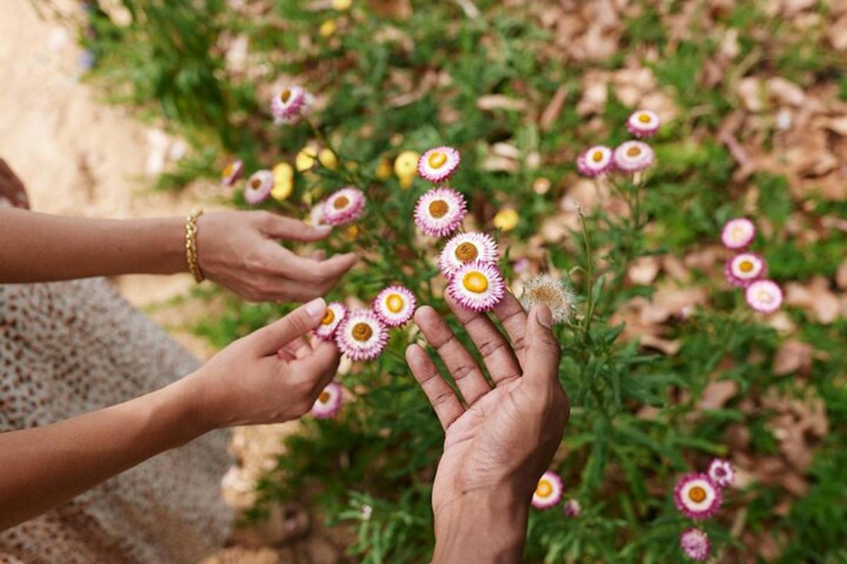 dalawang taong may hawak na bulaklak sa harap ng isang bush