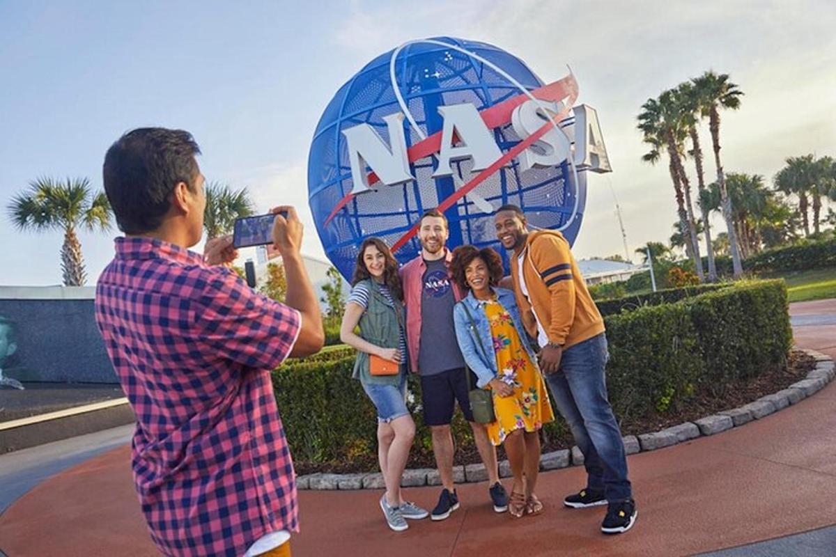 un uomo che scatta una foto a un gruppo di persone davanti a un grande globo