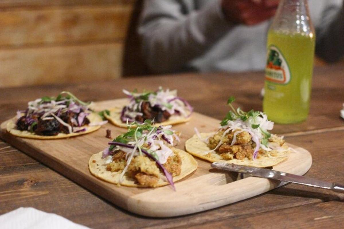 three tacos on a cutting board on a table