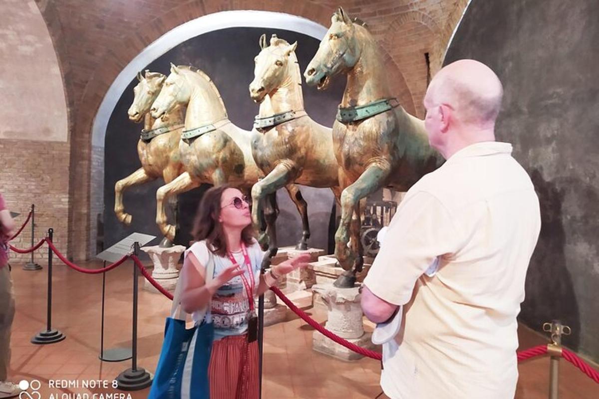 en mand og en kvinde står foran en statue af heste