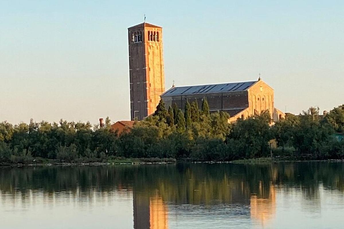 um edifício com uma torre de relógio próximo a um corpo d'água