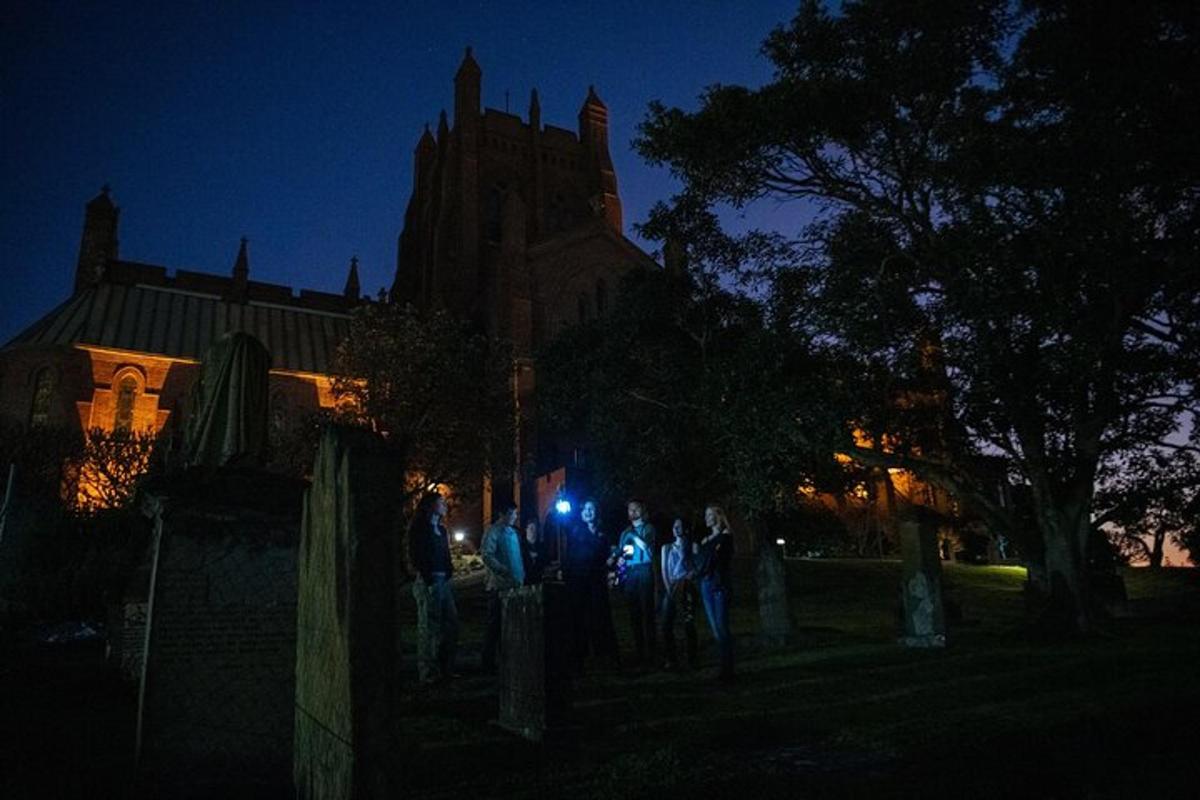 a group of people standing in front of a church at night
