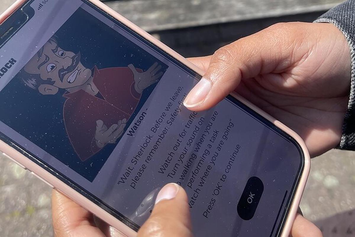 egy személy tartja a kezében a mobiltelefont, a képernyőn egy rajzfilmfigurával