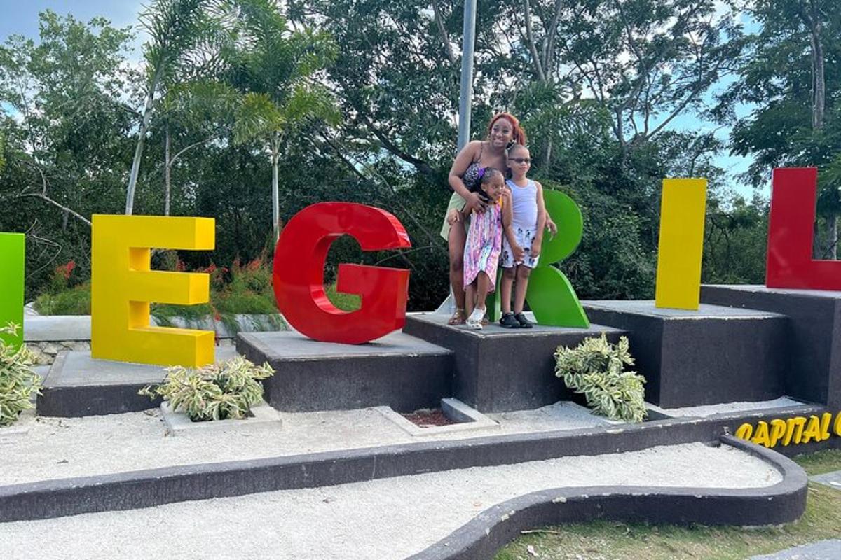 Una mujer y dos niños de pie frente a un cartel