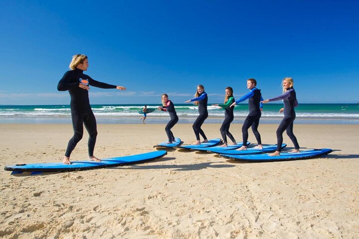 un grup de oameni care stăteau pe plăci de surf pe plajă