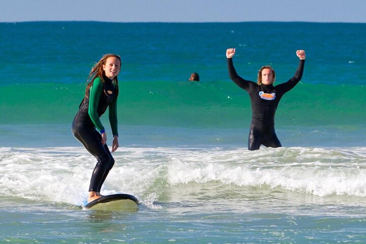 două femei stând pe plăci de surf în ocean