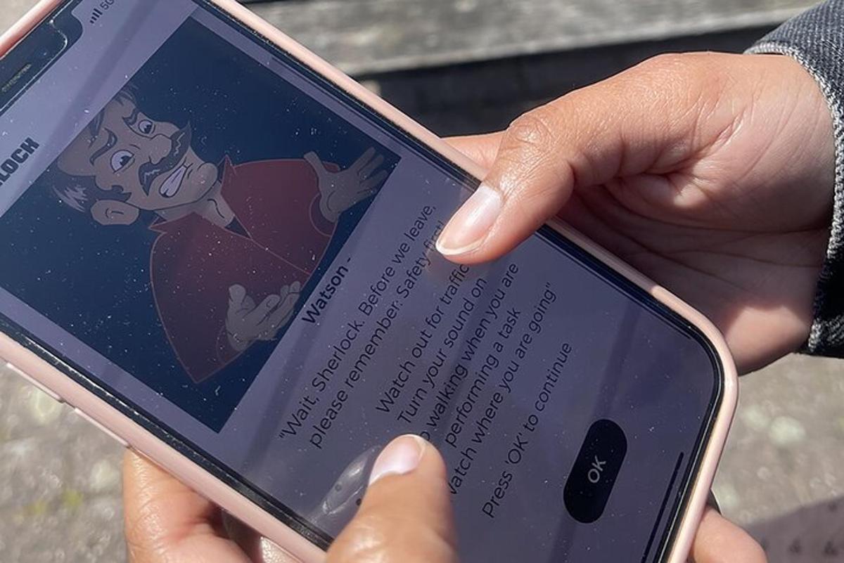 una persona che tiene in mano un telefono cellulare con un cartone animato sullo schermo