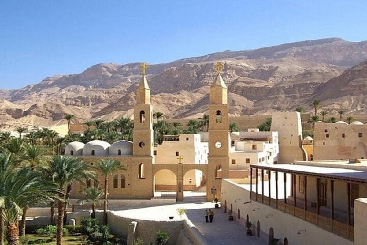 مبنى به برجين وأشجار نخيل وجبال