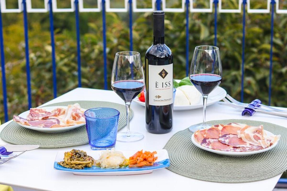 un tavolo con due bicchieri di vino e piatti di cibo