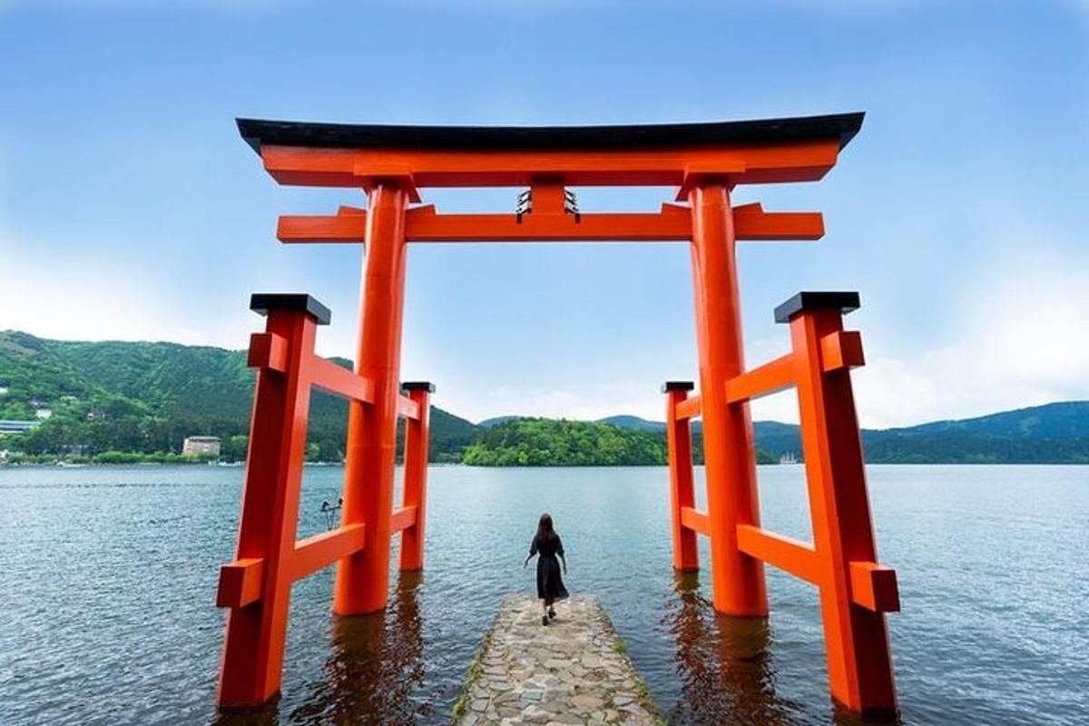 žena stojaca vo vode pod bránou torii